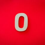 Close-up of a zero cutout on a bright red background with vibrant contrast.